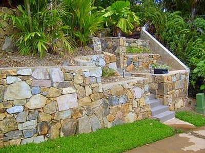 Stone retaining wall at front of the house Northern Land Design